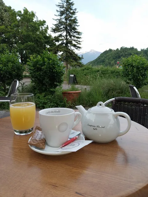 Tasse, théière et verre de jus sur une table en terrasse